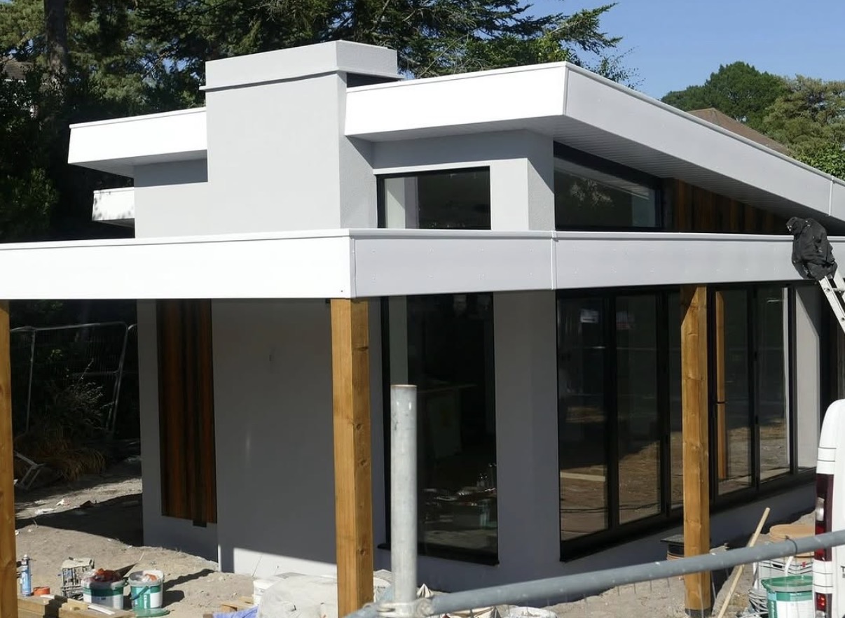 Contemporary house with smooth white render, timber columns and flat roof details