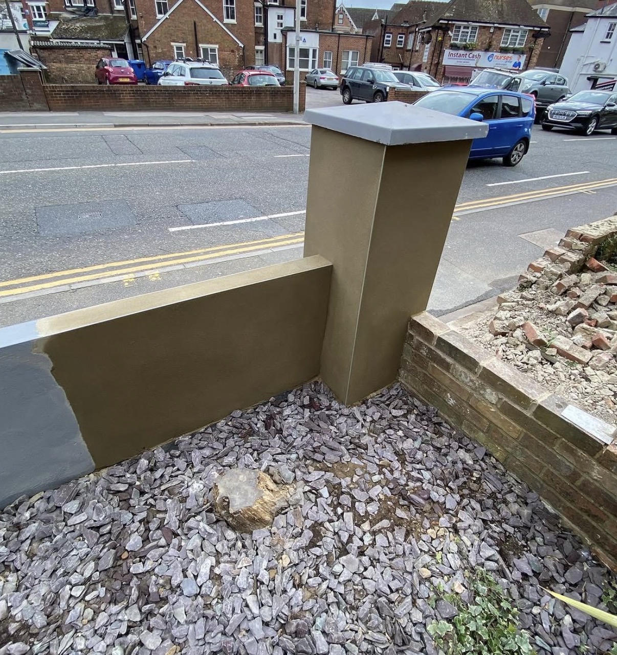 Rendered boundary wall and pillar finished in brown tone with grey coping stones
